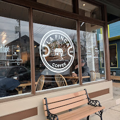 The round La Finca Coffee mark painted on the café window
